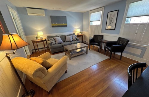 Newport Hotel | Dive into downtown Newport RI in this private, large, unique townhouse-style 2BR apartment at 205 Spring St! King and Full beds + pull-out sofa full kitchen, 2 baths, outdoor patio, AC, TVs, Wifi. Just steps to Thames Street, shops and wharfs